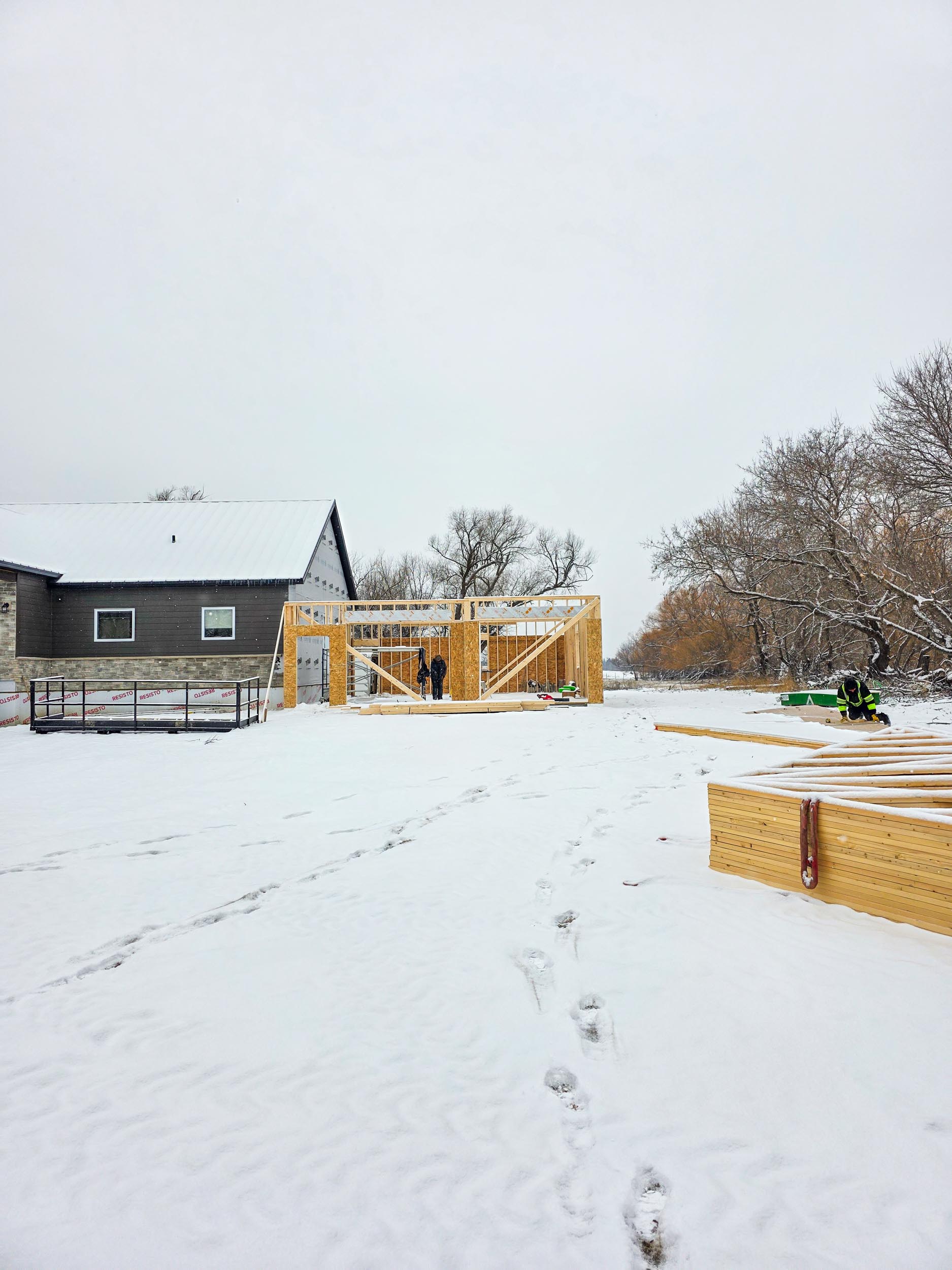Two-bay garage addition framed beside an existing house
